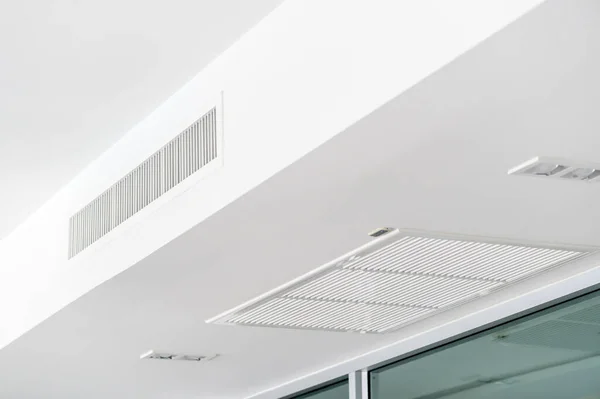 Ceiling mounted cassette type air conditioner and modern lamp light on white ceiling. duct air conditioner for home or office