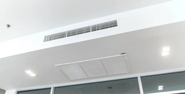 Ceiling mounted cassette type air conditioner and modern lamp light on white ceiling. duct air conditioner for home or office