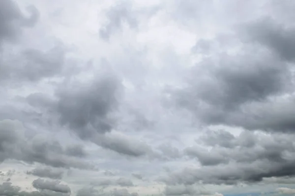 Storm clouds floating in a rainy day with natural light. Cloudscape scenery, overcast weather above blue sky. White and grey clouds scenic nature environment background.