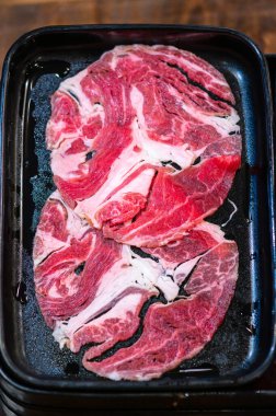 Slide raw beef for Yakiniku. Thin piece beef for Shabu hotpot japanese food style. Close up fresh meat chuck eye for Sukiyaki. top view.