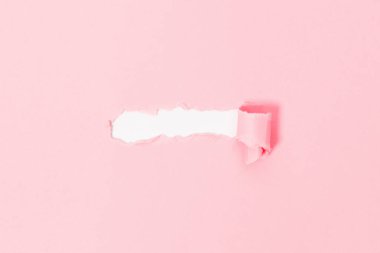 Beyaz arkaplandaki pembe yırtık kağıdın üst görüntüsü. Metin pankartı için boş alan.