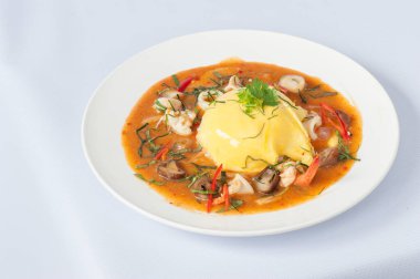 Beyaz arka planda izole edilmiş yumurta ve deniz mahsullü Tayland körisi