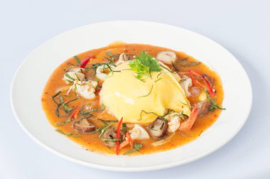 Beyaz arka planda izole edilmiş yumurta ve deniz mahsullü Tayland körisi