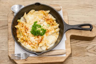 Peynirli fırında makarna ve üzerine parmesan serpiştirilmiş makarna. Yumuşak odak noktası.