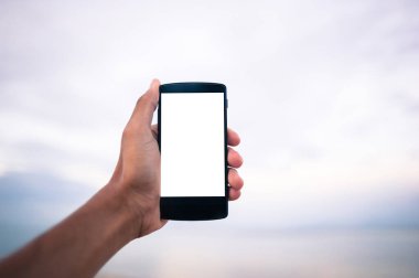 yakın çekim el bulanık doğa arka plan ile akıllı telefon tutarak