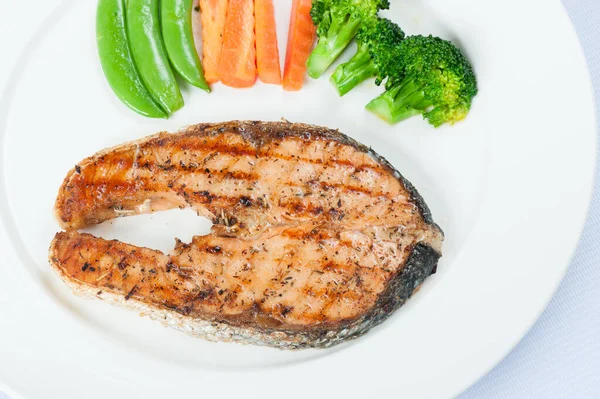 Grilled Salmon Steak with Boiled Vegetables Isolated on a White Background