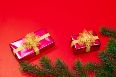 Noel konsepti. Noel hediyesi kutusunun üst manzarası ladin dalları ve kırmızı zili olan altın toplar..