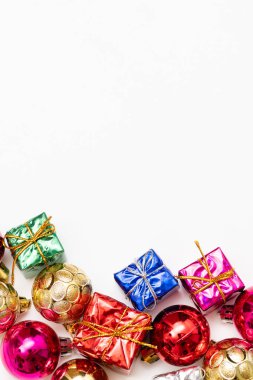 Köknar dalları, hediye kutuları, kırmızı süslemeler, parıltılar ve beyaz arka planda konfetilerden oluşan mutlu noel kartları. Noel ve Yeni Yıl tatili, Bokeh, ışık. Düz yatış, üst görünüm