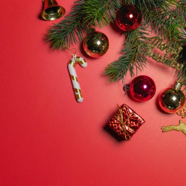 Noel konsepti. Noel hediyesi kutusunun üst görüntüsü ladin dalları ve kırmızı zili olan renkli toplar.