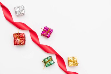 Köknar dalları, hediye kutuları, kırmızı süsleme, kurdele, ışıltı ve beyaz arka planda konfetiden oluşan mutlu noel kartları. Noel ve Yeni Yıl tatili, Bokeh, ışık. Düz yatış, üst görünüm