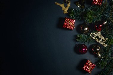 Noel konsepti. Noel hediyesi kutusunun üst görüntüsü ladin dallı renkli toplar ve siyah arka planda çan.