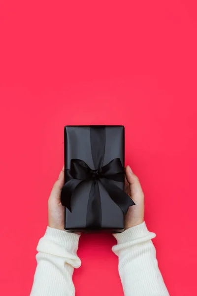 女性手拿着用黑丝带包裹的小礼物的特写镜头 带复制空间 横幅的假日礼物概念 — 图库照片