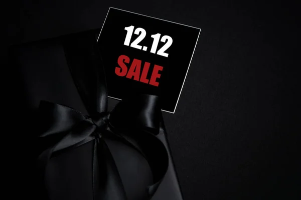 Top view of black gift box with black background with copy space for text 12.12 singles day sale. Online shopping of China, 12.12 singles day sale concept.