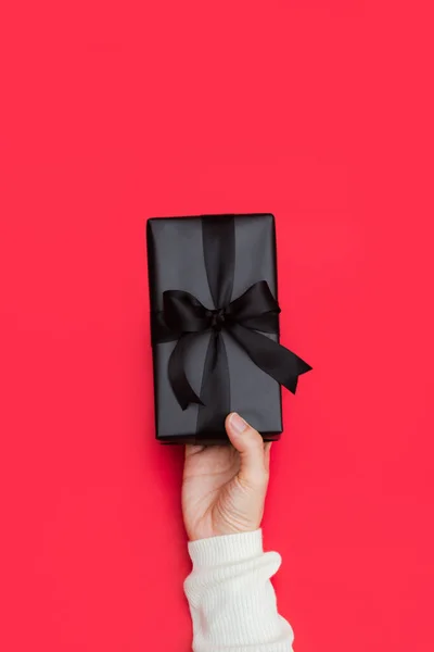 女性手拿着用黑丝带包裹的小礼物的特写镜头 带复制空间 横幅的假日礼物概念 — 图库照片