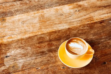Eski ahşap masadaki latte sanat kahvesi manzarası..