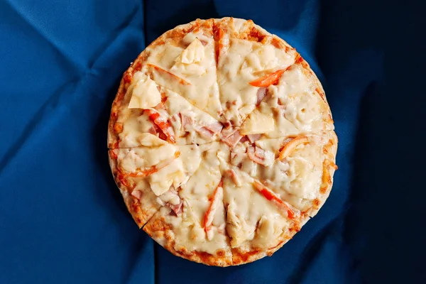 İtalyan yemeklerinin olduğu bir masa. Hawaii pizzası mavi masada yatıyordu..