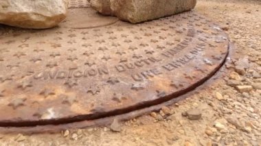 Eski rögar kapağı içerideki basınçtan dolayı titriyor. Metal kapak taşlara dayanıyor. Yol çalışmaları.