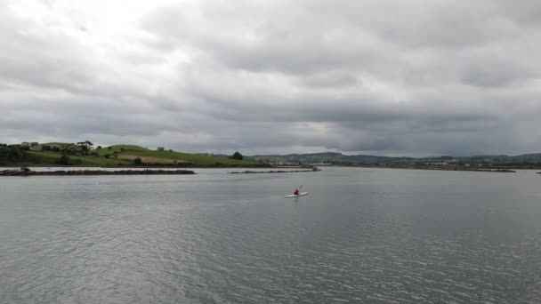 Ruhige Bucht. Der Mann mit dem Kanu. Spiegelwasser. Dorf am Meer. Bewölkt-launiger Tag an der Meeresküste. Schöne Küstenlandschaft mit grünen Wiesen. Kantabrien. Asturien. Jakobsweg. — Stockvideo