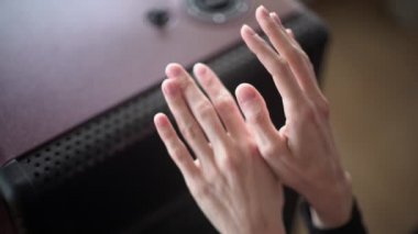 Close-up of hands at the heater. A girl warms her hands by the gas stove on a cold day. Winter cold. Warmth at home.