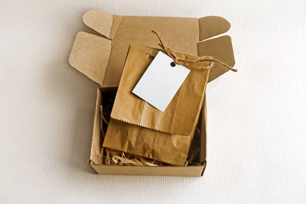 Papírové Sáčky Kraft Krabici Světlém Pozadí Prázdným Štítkem Šablona Balení — Stock fotografie