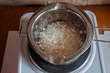 Ocağın üzerindeki metal bir tavaya sert balmumu dök.