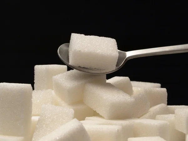 Sukkerterterninger og teskje – stockfoto