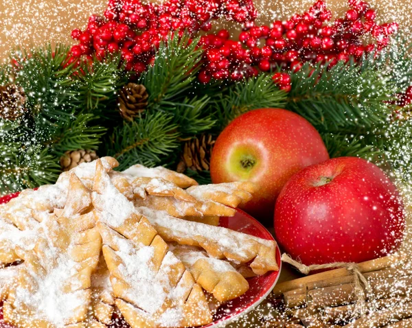 Pâtisserie sucrée et pommes rouges dans le cadre enneigé — Photo