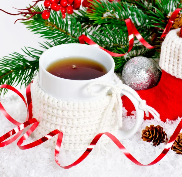Tazza di tè indossando un maglione a maglia in piedi sulla neve — Foto Stock