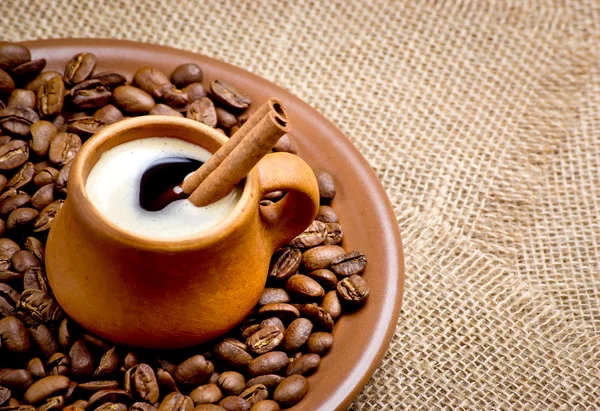 Koffie bonen in keramische plaat met kaneel — Stockfoto