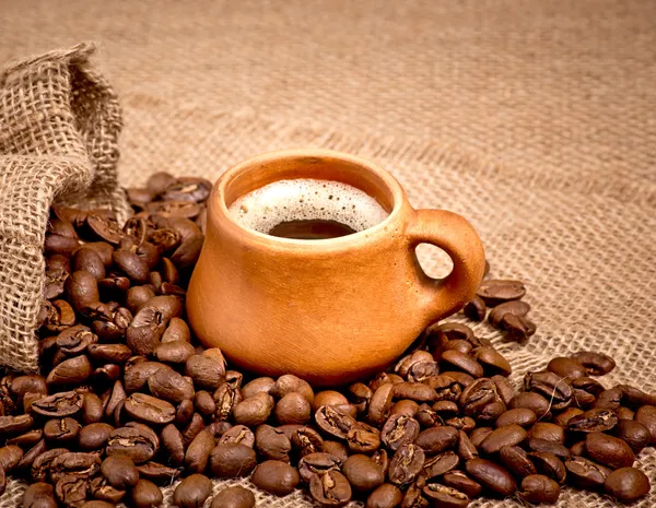 Coffee beans and clay cup — Stock Photo, Image