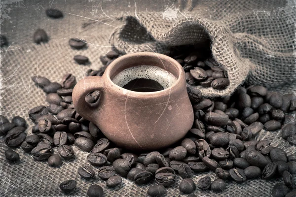 Kaffeebohnen und Tasse aus Ton im Retro-Stil — Stockfoto