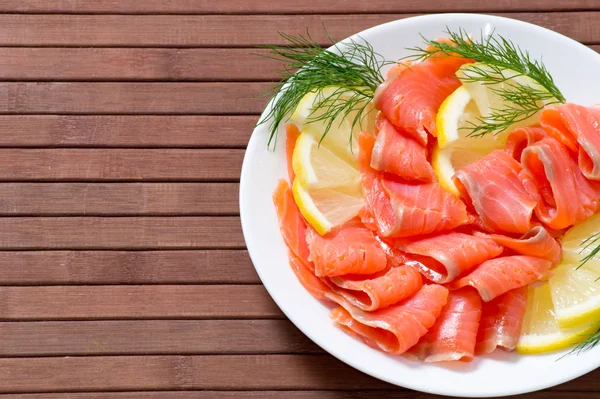 Salmón salado en rodajas servido con limón —  Fotos de Stock