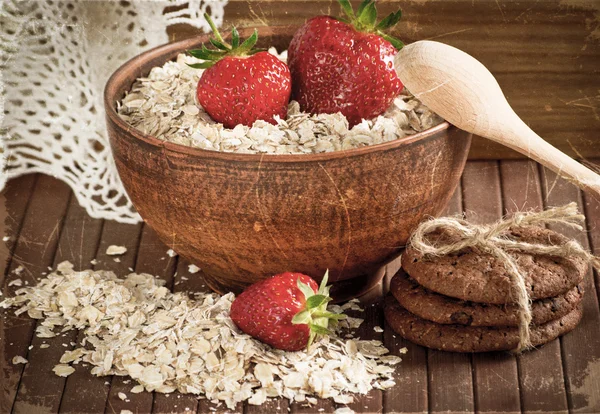 Havregrynsgröt med jordgubbar i en skål och cookies. — Stockfoto