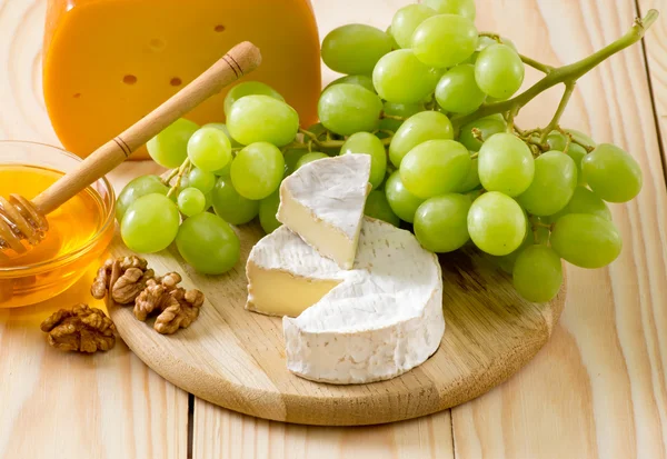 Bodegón de queso, miel, nueces y uvas — Foto de Stock