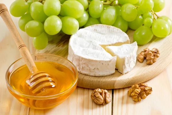 Bodegón de queso, miel, nueces y uvas — Foto de Stock
