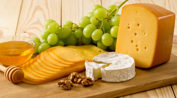 Bodegón de queso, miel, nueces y uvas — Foto de Stock