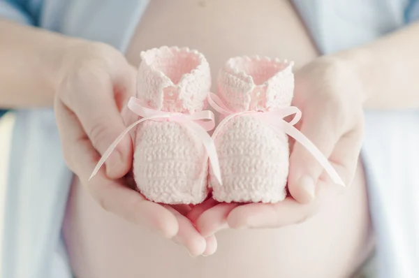 hamile kadın çocuğu ilk ayakkabı tutuyor