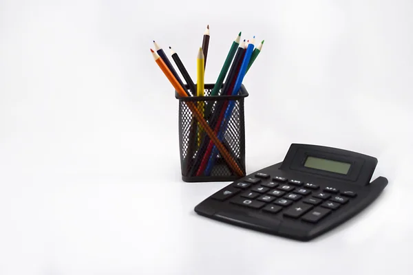 Kredki w posiadacz czarnego ołówka i kalkulator na biały — Zdjęcie stockowe