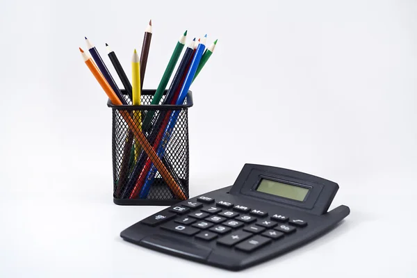 Färgpennor i en kalkylator på en vit och en svart penna innehavaren — Stockfoto