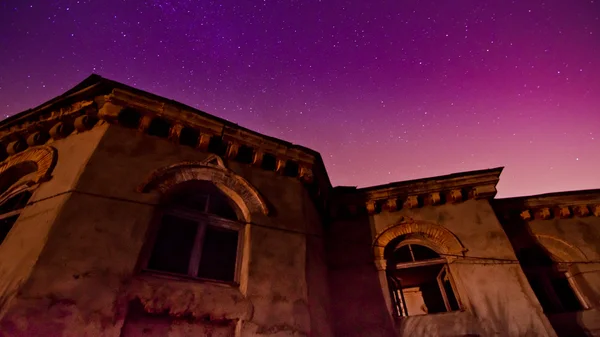 Pôr-do-sol roxo profundo atrás de um edifício de pedra — Fotografia de Stock