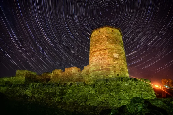 Antigua torre de piedra sobre fondo estrellado de skyes nocturnos — Foto de Stock