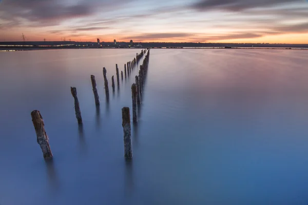 Polos na água - em nuvens de pôr-do-sol e oceano — Fotografia de Stock