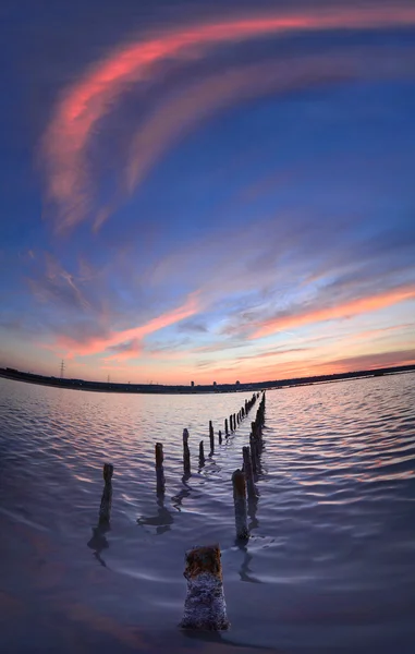 Πόλους στο νερό - σύννεφα στο ηλιοβασίλεμα και ωκεανό — Φωτογραφία Αρχείου