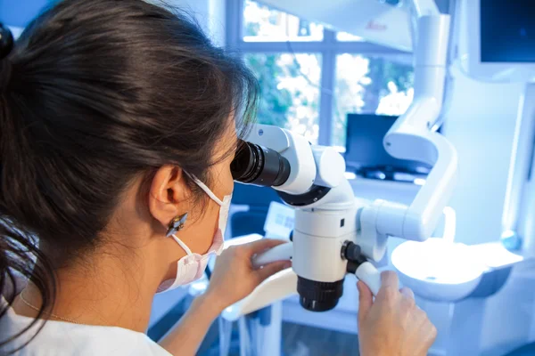 Femme travaillant avec un microscope en laboratoire — Photo