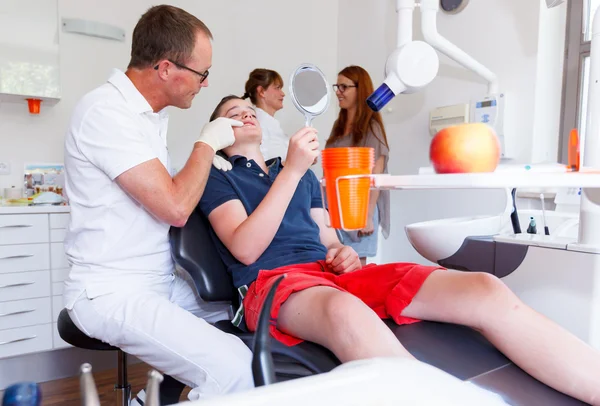 A doctor explains a young boy how he can care the teeth — Stock Photo, Image