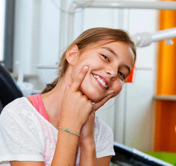 Menina engraçada e feliz em uma cirurgia dentária com grande sorriso . Imagem De Stock