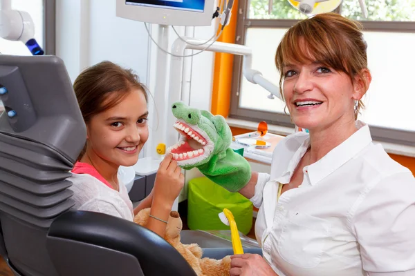 Un medico di odontoiatria gioca con una ragazza Foto Stock Royalty Free