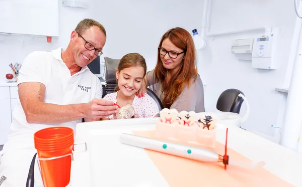 A doctor explains a young family how they can care the teeth Stock Photo