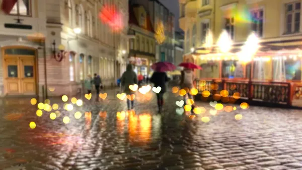 雨の光の交通信号で夜市を横断する道路上の傘で女性のシルエットを焦点を当てる湿ったアスファルト上を横断するストライプ — ストック写真