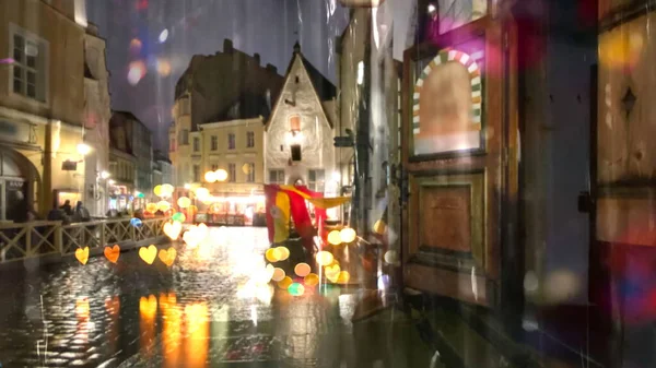 集中豪雨ぬれた中世都市の夜の木の家雨の光湿式アスファルトの赤いテントの夜の都市秋の雨タリン旧市街エストニア — ストック写真